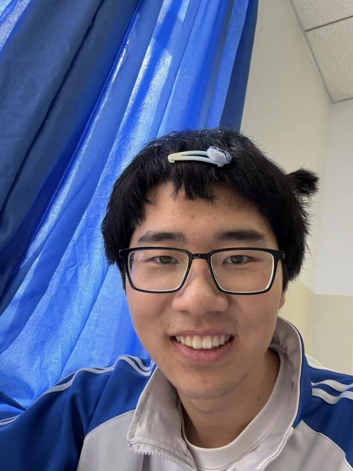 汪子轩戴着眼镜,对着镜头微笑